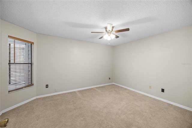 unfurnished room with a textured ceiling, a ceiling fan, baseboards, and light carpet