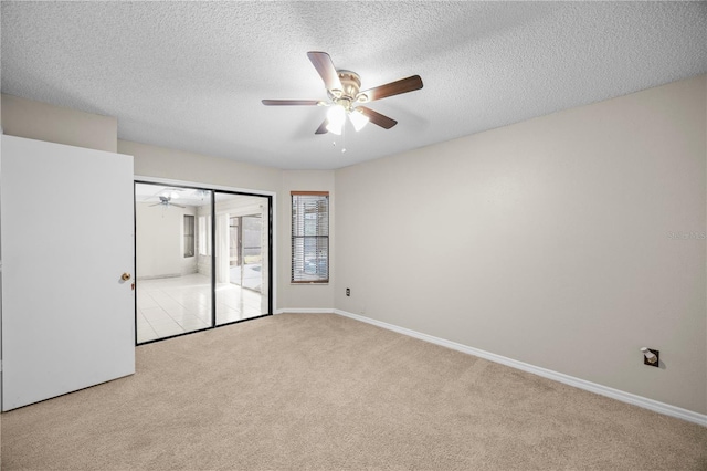 unfurnished bedroom featuring a ceiling fan, a textured ceiling, a closet, carpet, and baseboards