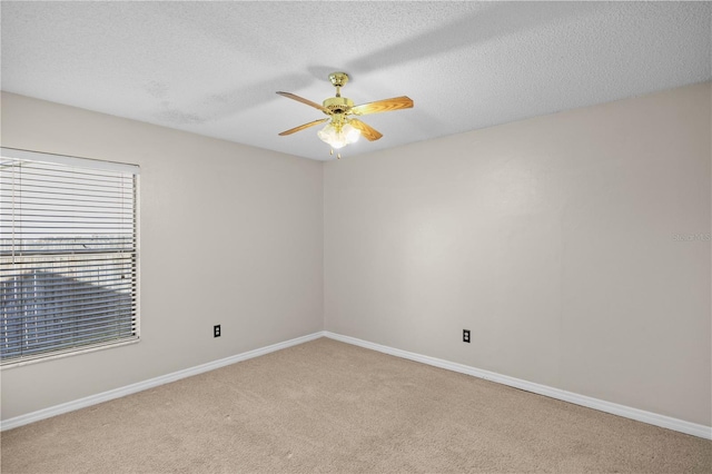 spare room featuring light colored carpet, ceiling fan, and a textured ceiling