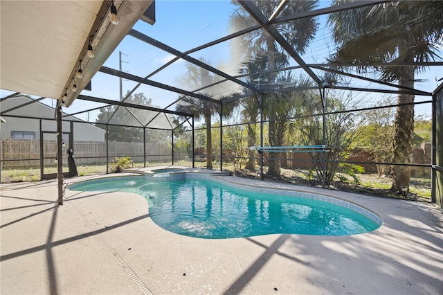 view of pool with a patio, fence, a pool with connected hot tub, and a lanai