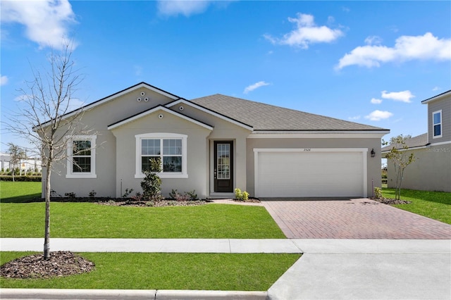 ranch-style home featuring a shingled roof, stucco siding, a front lawn, a garage, and decorative driveway