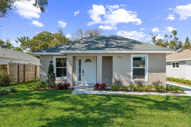 bungalow featuring stucco siding, roof with shingles, a front yard, and fence