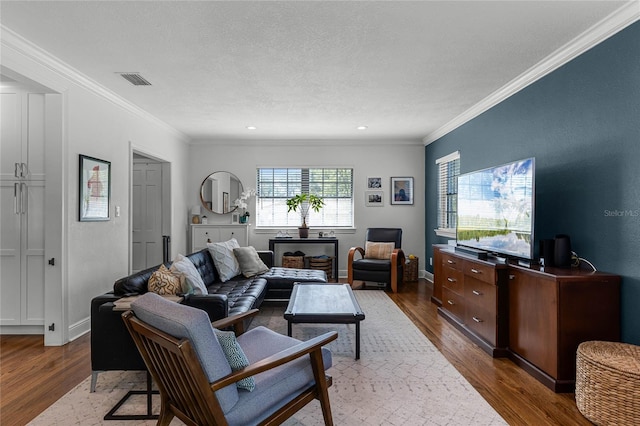 living room featuring baseboards, dark wood-type flooring, crown molding, and a textured ceiling