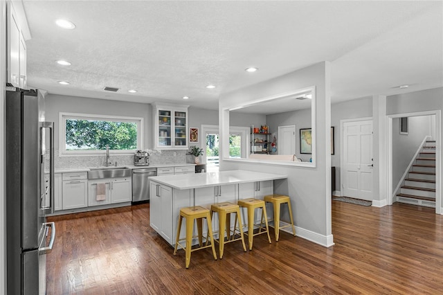 kitchen with a sink, a breakfast bar area, a wealth of natural light, and stainless steel appliances