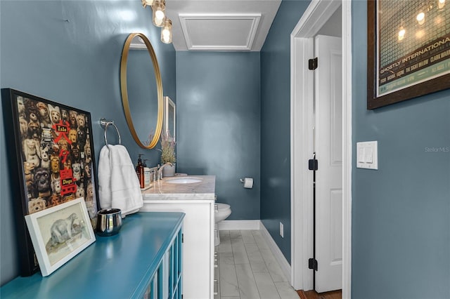 bathroom with toilet, vanity, and baseboards