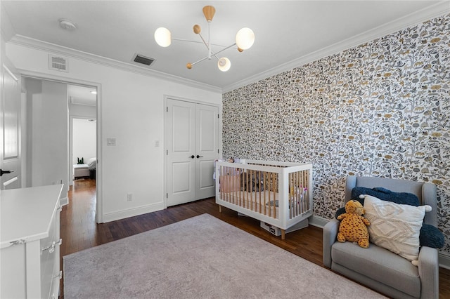 bedroom featuring wallpapered walls, wood finished floors, visible vents, and ornamental molding