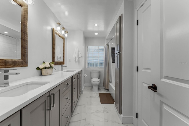 bathroom featuring double vanity, toilet, marble finish floor, and a sink