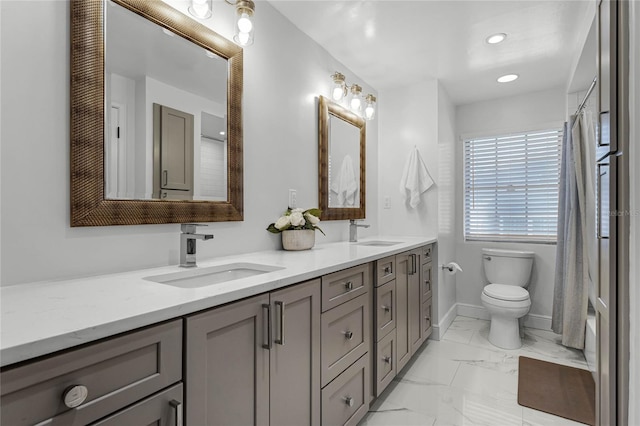 bathroom with double vanity, marble finish floor, toilet, and a sink