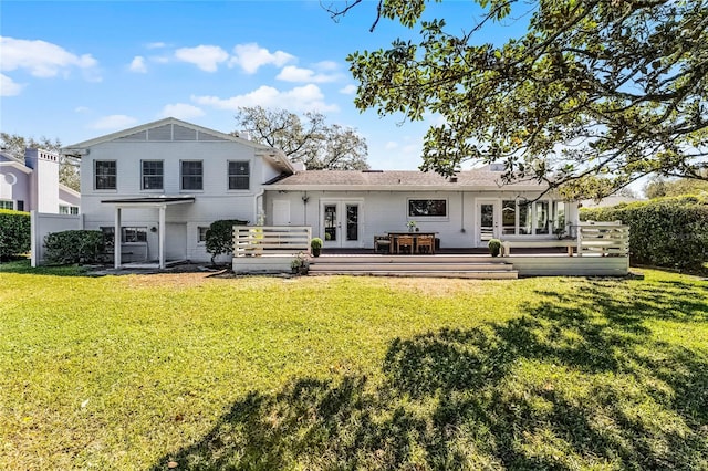 back of property featuring a deck, a yard, and french doors