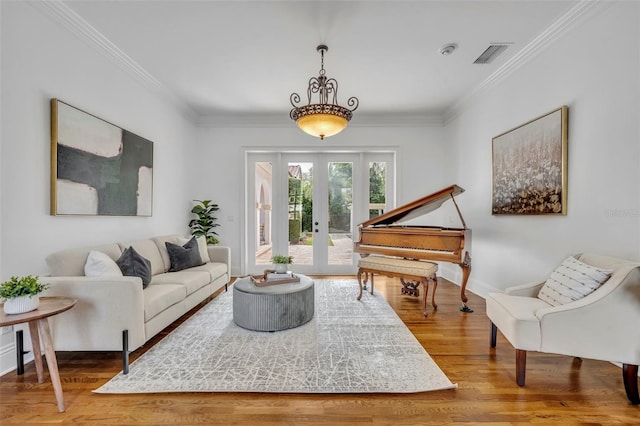 living room with visible vents, crown molding, baseboards, french doors, and wood finished floors