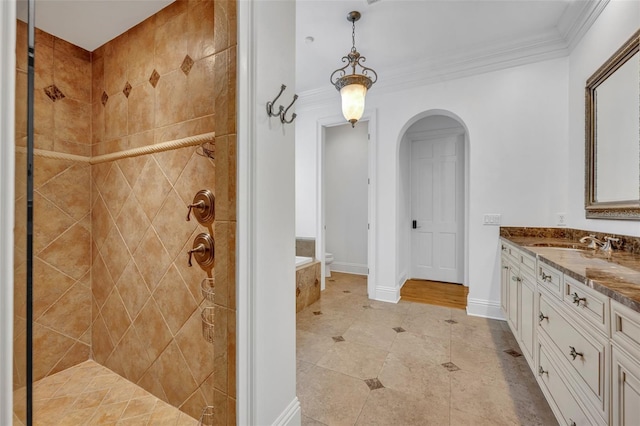 bathroom featuring vanity, crown molding, baseboards, and a tile shower