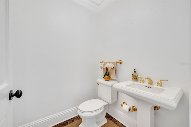 bathroom featuring baseboards and toilet