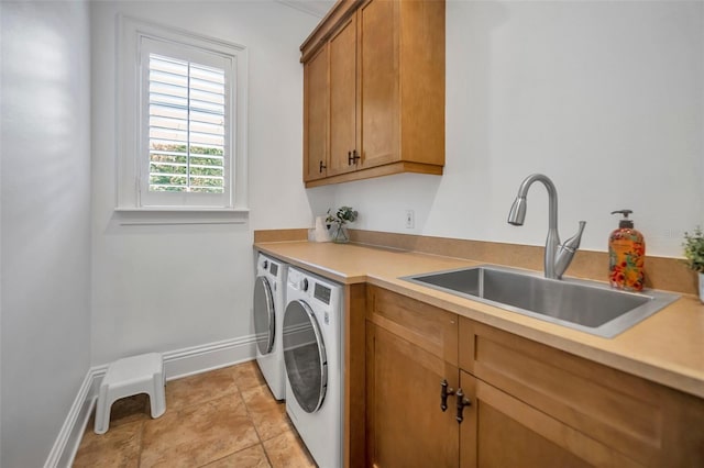 clothes washing area featuring a sink, baseboards, light tile patterned flooring, cabinet space, and separate washer and dryer