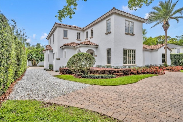 mediterranean / spanish home with stucco siding and a tile roof