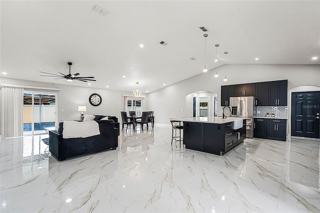 kitchen with visible vents, a kitchen breakfast bar, open floor plan, stainless steel fridge with ice dispenser, and light countertops