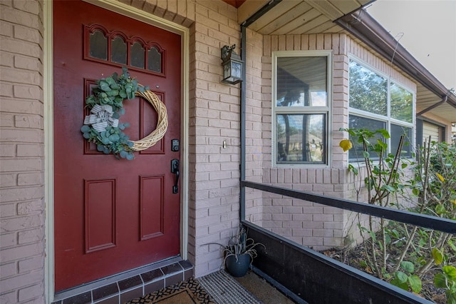 entrance to property featuring brick siding