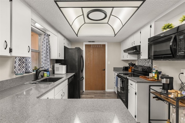 kitchen with black appliances, a sink, under cabinet range hood, a textured ceiling, and white cabinets