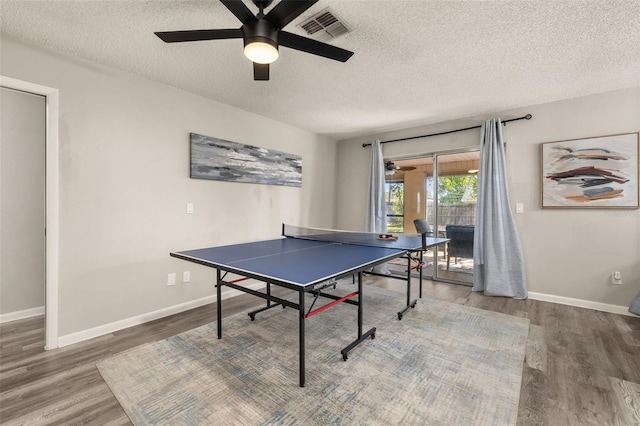 recreation room with visible vents, baseboards, ceiling fan, and wood finished floors