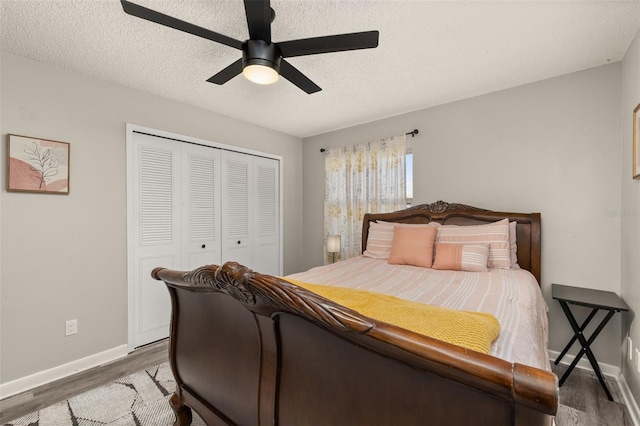 bedroom featuring a closet, a textured ceiling, a ceiling fan, and wood finished floors