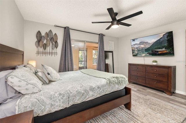 bedroom featuring a textured ceiling, wood finished floors, and a ceiling fan