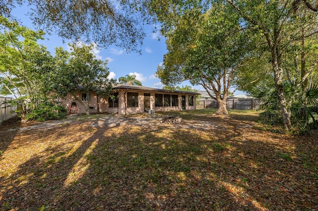 back of property featuring stucco siding, a fenced backyard, and a sunroom