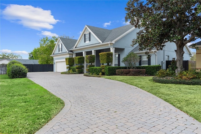 view of front facade featuring decorative driveway, stucco siding, a front yard, and fence