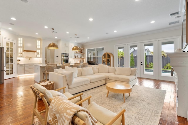 living room featuring french doors, hardwood / wood-style floors, and crown molding