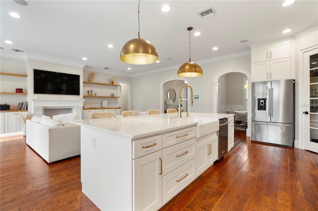 kitchen with visible vents, dark wood-type flooring, appliances with stainless steel finishes, arched walkways, and a sink