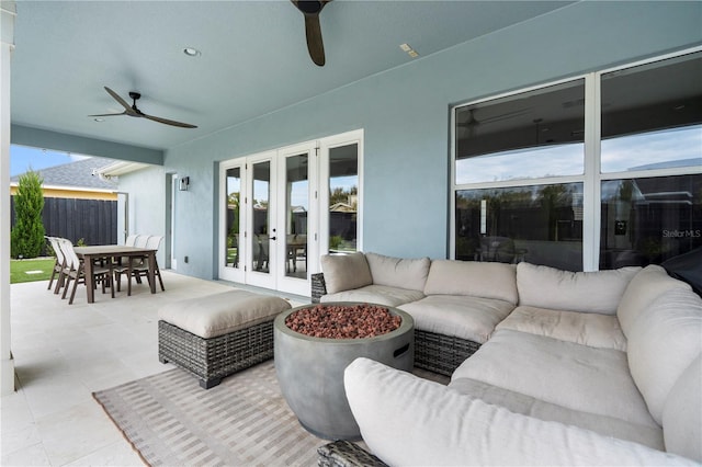 view of patio / terrace with a ceiling fan, fence, french doors, an outdoor living space with a fire pit, and outdoor dining area