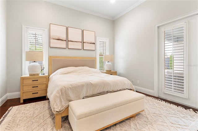 bedroom with wood finished floors, baseboards, and ornamental molding