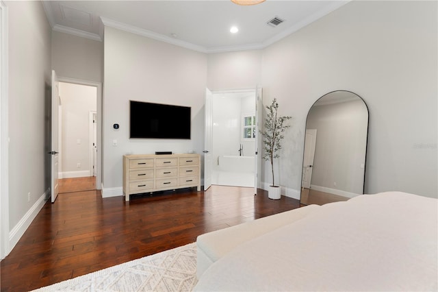 bedroom with visible vents, hardwood / wood-style floors, arched walkways, crown molding, and baseboards