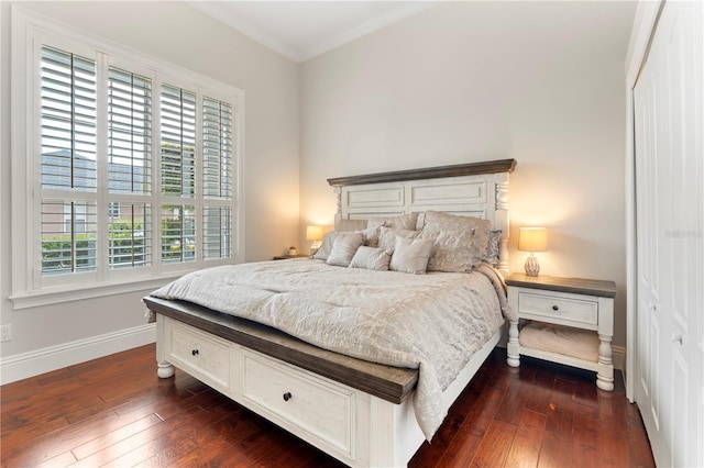 bedroom featuring baseboards, dark wood finished floors, and crown molding