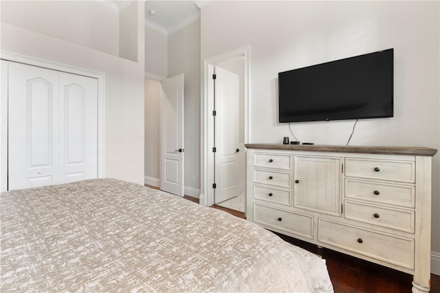 unfurnished bedroom featuring a closet, baseboards, dark wood-style floors, and crown molding