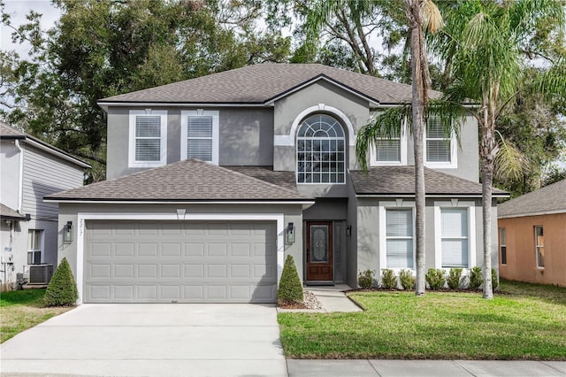 traditional-style home with a front yard, roof with shingles, and stucco siding