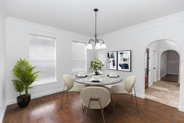 2217 Wekiva Reserve Blvd, Apopka, FL 32703 - dining space featuring a chandelier, ornamental molding, arched walkways, baseboards, and wood-type flooring