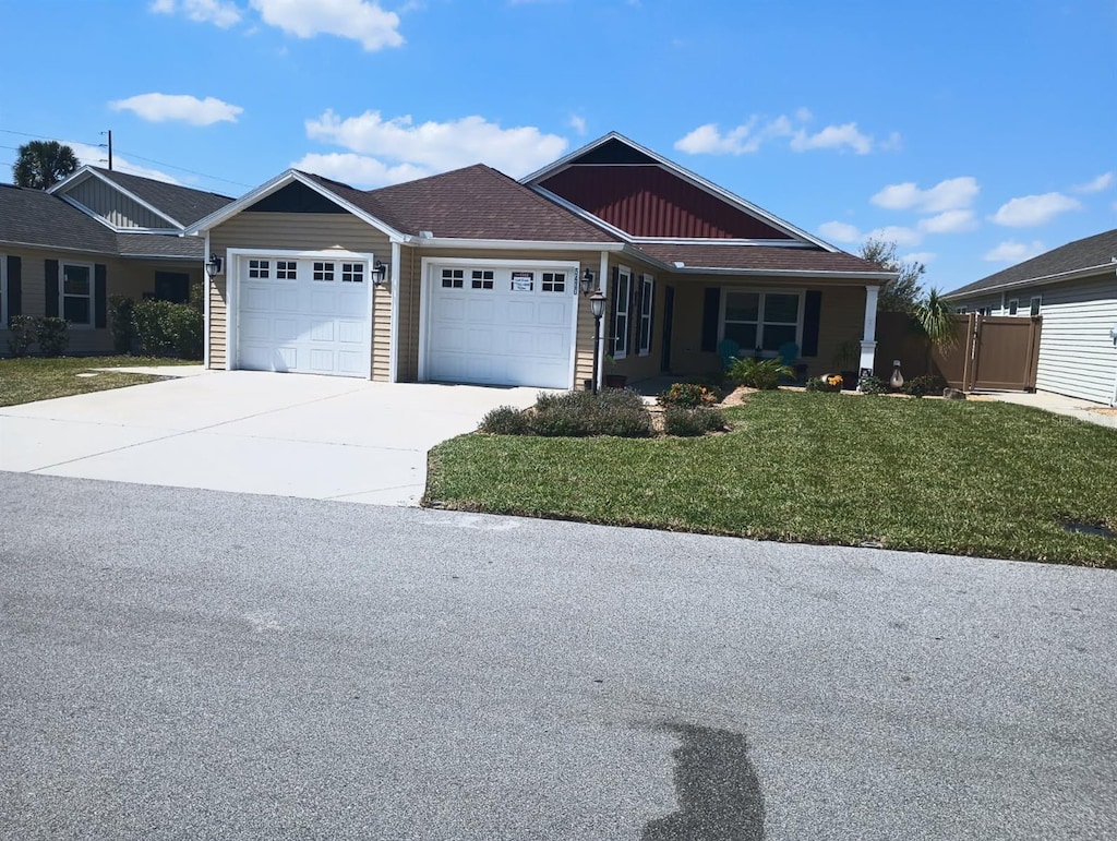 view of front of home with a garage, concrete driveway, and a front yard