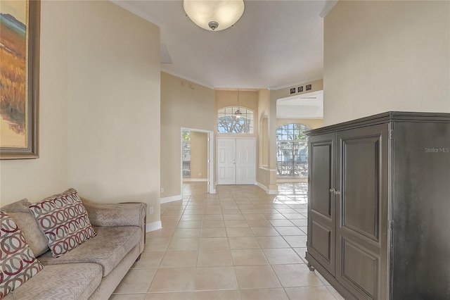 foyer with crown molding, light tile patterned flooring, and baseboards