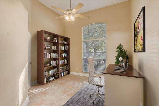 office space featuring light tile patterned floors, a ceiling fan, and baseboards