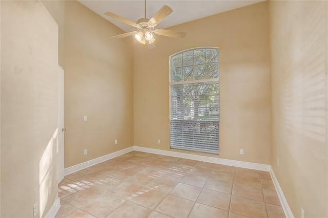 unfurnished room featuring light tile patterned floors, a ceiling fan, and baseboards