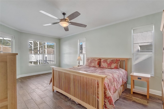 bedroom featuring baseboards, wood finished floors, and crown molding