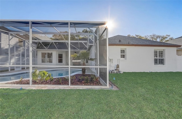 view of property exterior with an outdoor pool, stucco siding, a yard, and glass enclosure