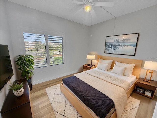 bedroom with a ceiling fan, baseboards, and wood finished floors