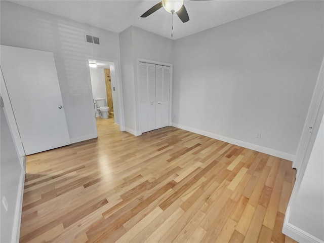 unfurnished bedroom with a closet, visible vents, light wood-type flooring, and baseboards