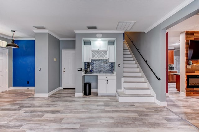 interior space featuring wood finished floors, visible vents, and ornamental molding