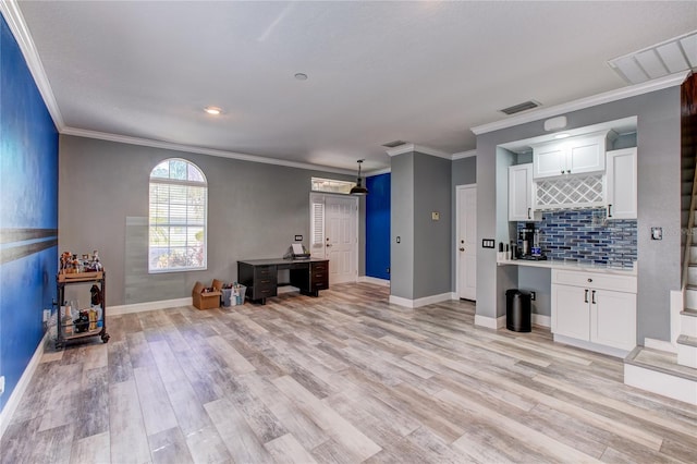 living area featuring visible vents, a dry bar, baseboards, and light wood-style floors