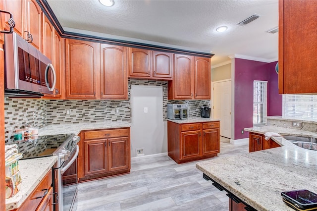 kitchen with visible vents, stainless steel appliances, crown molding, and light stone countertops