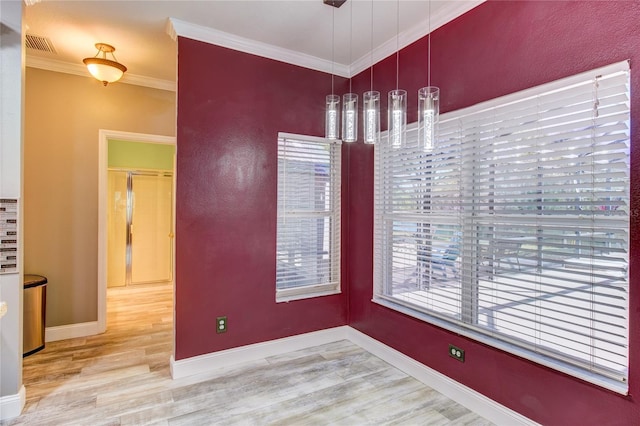 dining room with crown molding, wood finished floors, baseboards, and visible vents