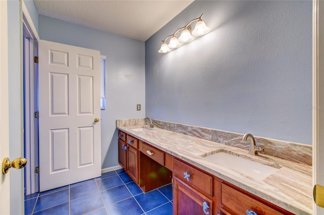 bathroom with tile patterned floors, double vanity, a textured ceiling, and a sink