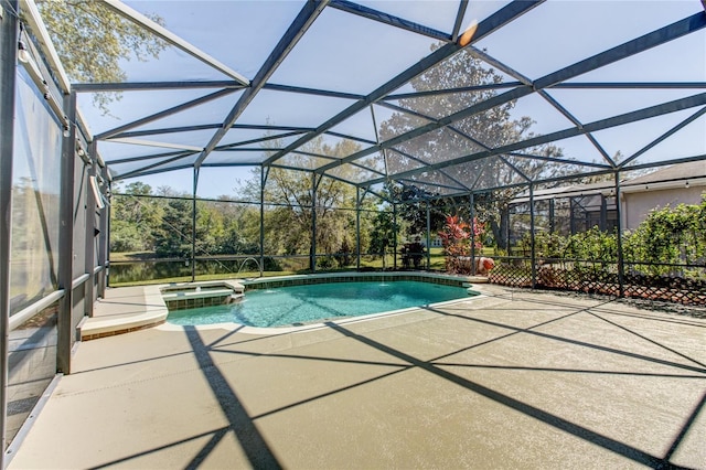 view of pool with glass enclosure, a patio, and a pool with connected hot tub