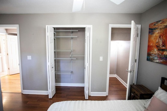 bedroom with wood finished floors, a closet, and baseboards